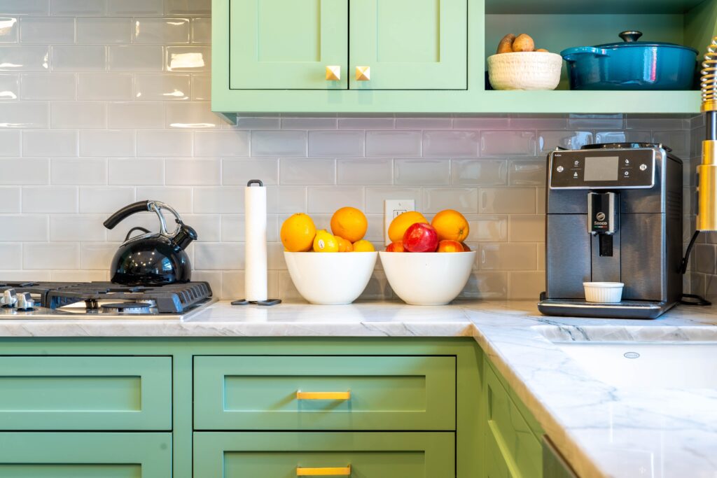 Quartzite kitchen countertops with green cabinetry.